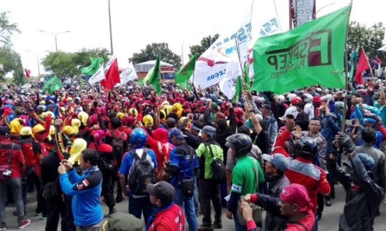 Ribuan buruh memblokir jalan di perempatan lampu merah Damkar, Kecamatan Grogol, Kota Cilegon. (Foto: TitikNOL)