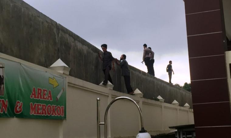 Petugas dibantu sejumlah warga tengah melakukan pencarian tahanan yang kabur di sekitar lokasi Pengadilan Negeri Serang. (Foto: TitikNOL)