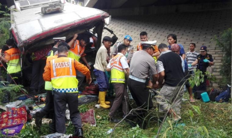 Petugas kepolisian yang dibantu petugas dari tol dan warga saat mengevakuasi penumpang bus SM Prima yang mengalami kecelakaan tunggal di KM 86 Tol Tengerang -Merak. (Foto: TitikNOL)
