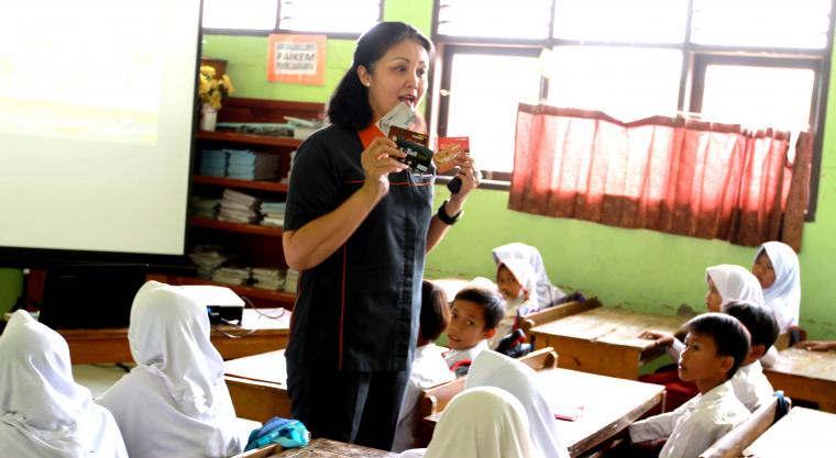 Presiden Direktur MMS Wiwiek D Santoso memperkenalkan uang elektronik kepada para siswa SD di Pejaten 1, Kramatwatu, Kab Serang. (Foto: Ist)