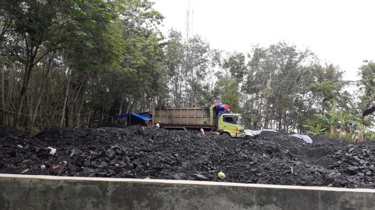 Stockpile (penyimpanan) batu bara di samping gedung SDN 2 Pamubulan Desa Pamubulan Kecamatan Bayah Kabupaten Lebak. (Foto: TitikNOL)