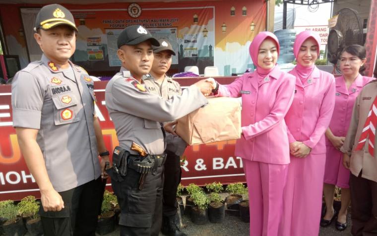 Kapolres Serang AKBP Indra Gunawan didampingi Ketua Pengurus Cabang Bhayangkari Serang, Widya Indra Gunawan memberikan bingkisan di pos pam Ciujung, Jumat (1/6/2019). (Foto: TitikNOL)