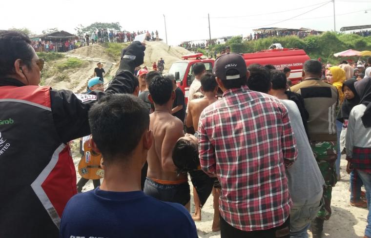 Warga membawa jasad korban tenggelam usai ditemukan. (Foto: TitikNOL)