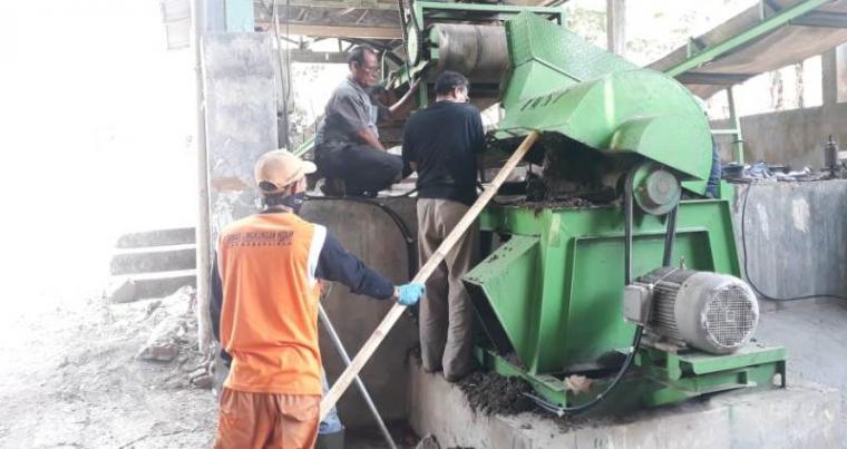 Para petugas pengolahan sampah Dinas Lingkungan Hidup Kota Serang saat memperbaiki mesin pencacah sampah yang macet. (Foto: TitikNOL)