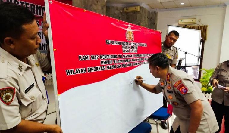 Kapolres Cilegon AKBP Yudhis Wibisana menandatangani pencanangan pembangunan Zona Integritas (ZI) menuju Wilayah Bebas Korupsi (WBK) dan Wilayah Birokrasi Bersih Melayani (WBBM) di Aula Polres Cilegon. (Foto: TitikNOL)
