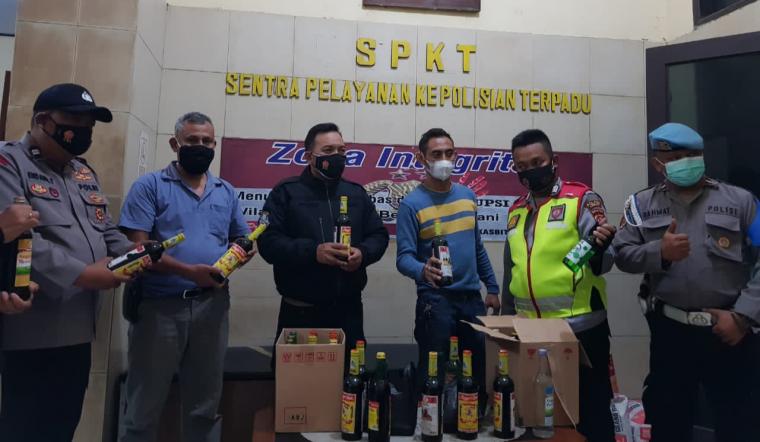 AKP Malik Abraham Kapolsek Rangkasbitung (tengah jaket hitam) saat memperlihatkan hasil operasi miras di sejumlah toko dan warung yang ditengarai sebagai penjual miras. (Foto: TitikNOL)