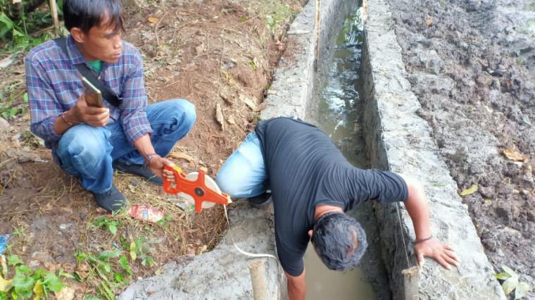 Arif Hidayat dan Meri, memeriksa kedalaman pondasi P3 - TGAI Desa Parage, Kecamatan Cikulur, Kabupaten Lebak, diduga pondasi bangunan tidak digali. (Foto: TitikNOL)