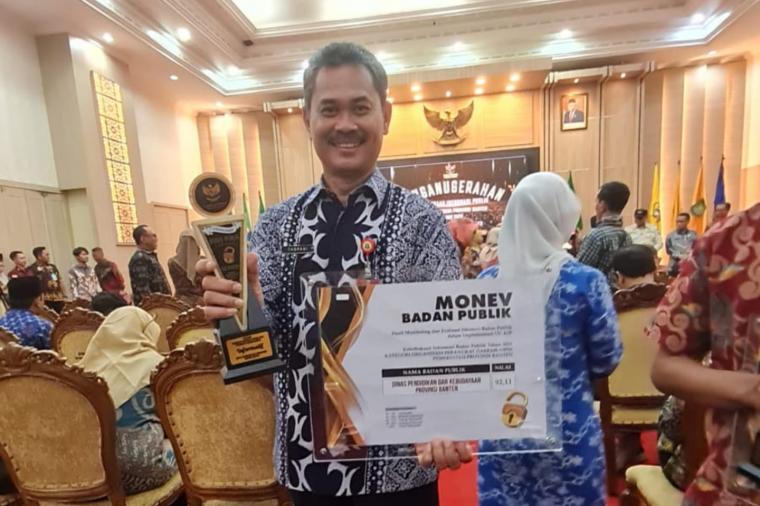 Kepala Dindikbud Provinsi Banten Tabrani menerima penghargaan Badan Publik Informatif. (Foto: TitikNOL)