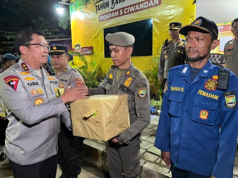 Kapolda Banten Irjen Pol Abdul Karim saat memberikan bingkisan kepada petugas yang mengamankan Libur Natal dan Tahun Baru 2024. (Foto: TitikNOL)