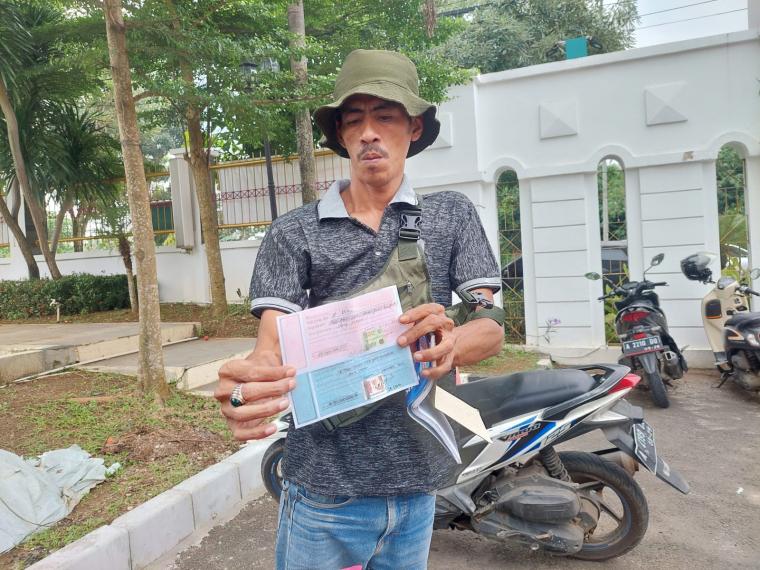 Pengusaha yang mengaku ditipu oknum pegawai Kejati Banten saat menunjukan bukti kwitansi pemberian uang senilai Rp80 juta. (Foto: TitikNOL)