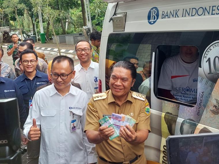 Simulasi penukaran uang yang dilakukan Pj Gubernur Banten Al Muktabar dan Kepala Perwakilan BI Provinsi Banten Ameriza Ma'ruf Moesa (baju putih) di loket mobil keliling (Foto: TitikNOL)