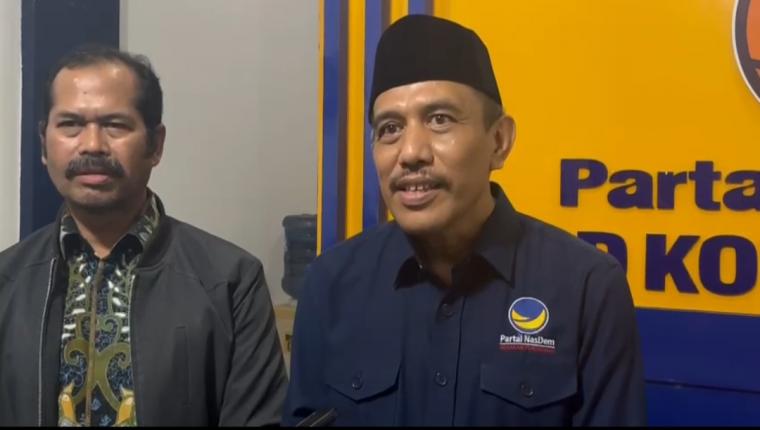 Ketua DPW Partai NasDem Roni Alfanto (peci hitam) saat diwawancara wartawan. (Foto: TitikNOL)